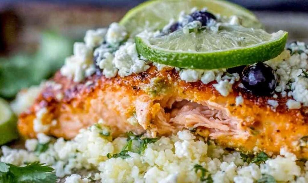Sheet pan honey chipotle salmon with cauliflower rice, black beans, and avocado coconut cream on a baking sheet
