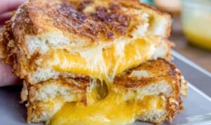grilled cheese Best grilled cheese recipe pulled apart to show melty cheddar cheese stretch with crispy golden challah bread
