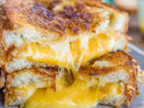 Best grilled cheese recipe pulled apart to show melty cheddar cheese stretch with crispy golden challah bread