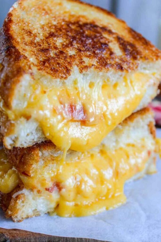 Best grilled cheese recipe pulled apart to show melty cheddar cheese stretch with crispy golden challah bread