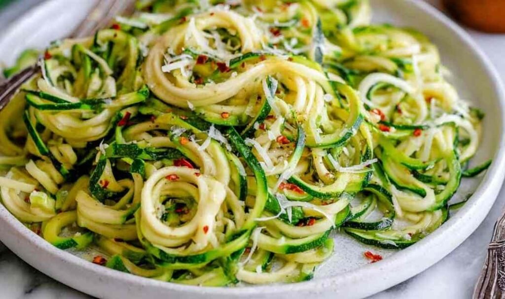 How to make zoodles — sautéed zucchini noodles in a skillet with garlic and Parmesan cheese