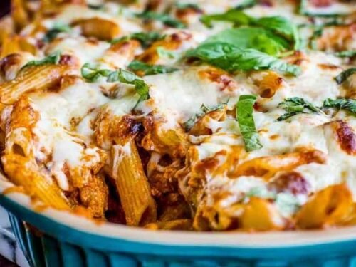 Extra cheesy penne and mozzarella casserole in a 9x13 baking dish with golden bubbly cheese across the top