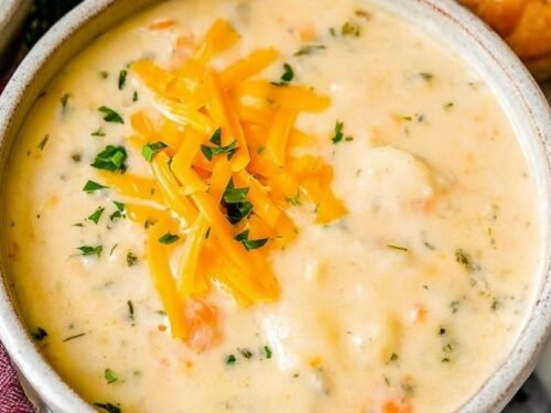 Chopped russet potatoes and diced carrots boiling in a pot for potato soup.