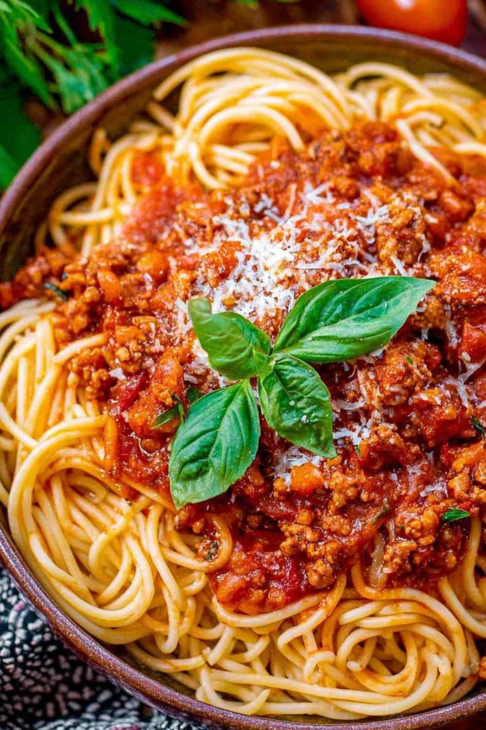 Ingredients for easy spaghetti sauce including sausage and marinara in a Dutch oven